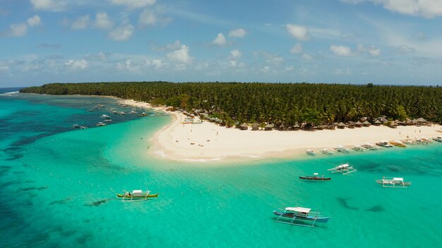 Isla tropical de daco con una playa de arena y turistas