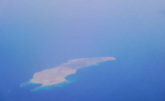 isla única con arrecife de coral en la vista del mar azul profundo durante un vuelo de vacaciones