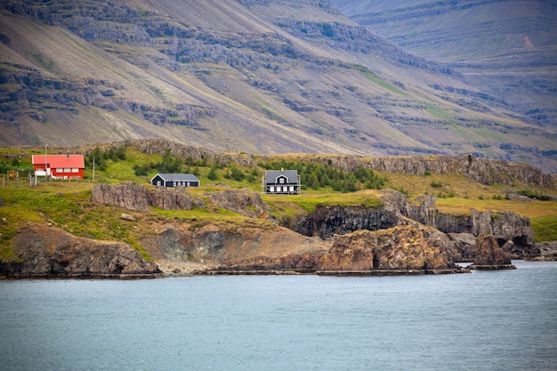 Isländische Landschaft: Häuser in den nebeligen Bergen