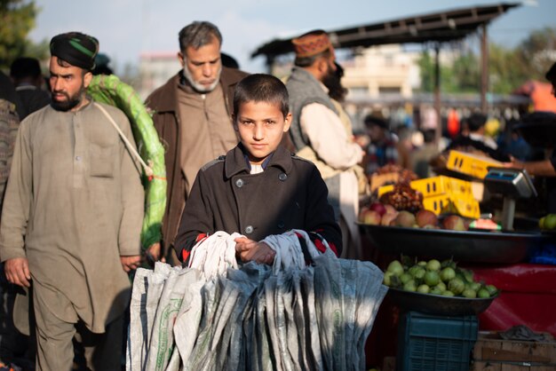 Islamabad, Islamabad Capital Territory, Pakistan - 2. Februar 2020, Ein Junge verkauft Tragetaschen auf dem Gemüsemarkt.