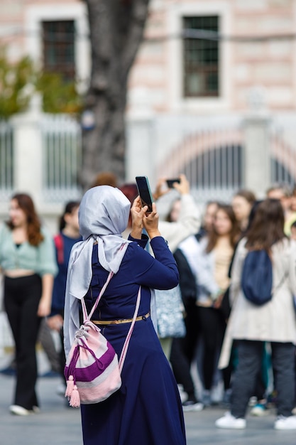 Islamische Frau, die Fotos auf der Rückansicht des Telefons macht Videoaufnahme mit Handykamera mit Smartphone, um Bilder im Freien zu machen Touristisches Fotografieren von Landschaft Sightseeing-Konzept