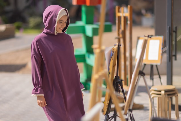 Islamische schöne Frau in einem muslimischen Kleid, das auf einem Sommerparkstraßenhintergrundwaldherbstbäumen steht. Welt-Hijab-Tag.