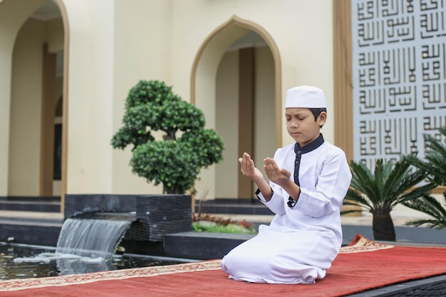 Islamischer Internatsschüler betet im Innenhof der Moschee zu Gott