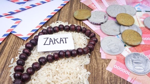 Islamisches Zakat-Konzept Selektives Fokusbild Reis Indonesien Rupiah Geld mit Gebetsperlen