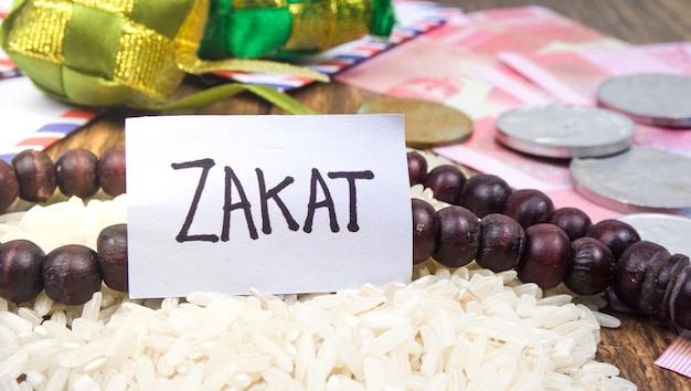 Islamisches Zakat-Konzept Selektives Fokusbild Reis Indonesien Rupiah Geld mit Gebetsperlen