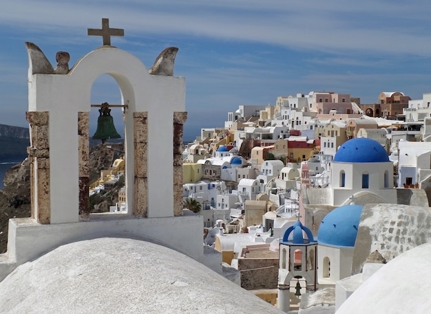 Islas griegas de estilo campanario y cúpulas azules de la iglesia en el pueblo de Oia, isla de Santorini, Grecia