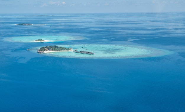 Islas tropicales y atolones en Maldivas desde la vista aérea.