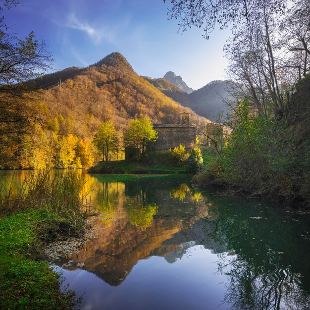 Isola Santa pueblo medieval y lago en el follaje de otoño Garfagnana Toscana Italia