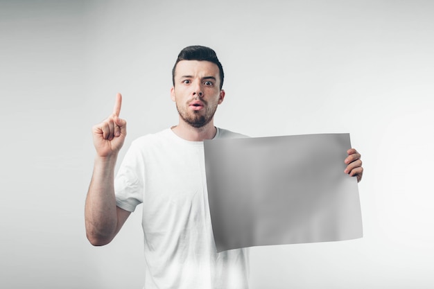 Isolado no fundo branco, homem segura um cartaz