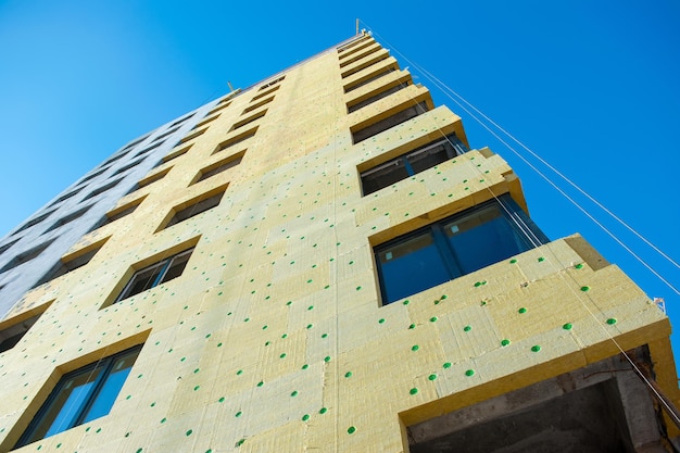 Isolamento da parede de uma casa monolítica em construção com isolamento amarelo