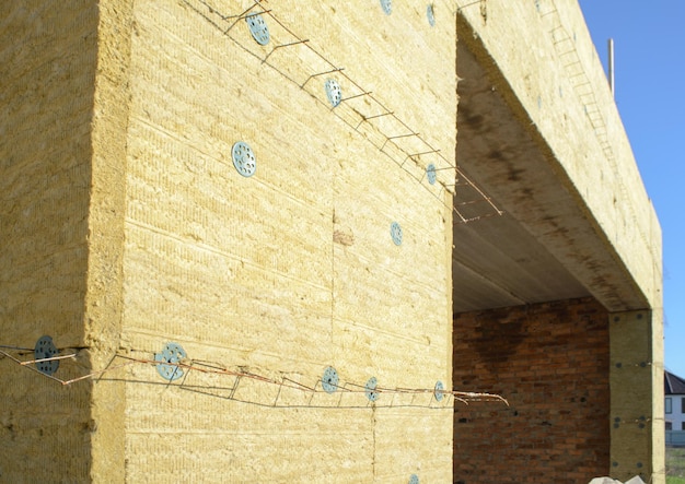 Isolamento térmico da parede exterior com lã mineral em casa particular em construção