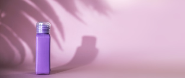 Isolierte Spa-Kosmetikprodukte lila Tube auf rosa Hintergrund
