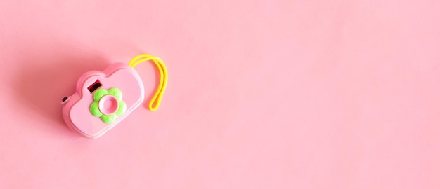 Isolierte Spielzeugkamera rosa Farbe auf rosa Hintergrund Draufsicht