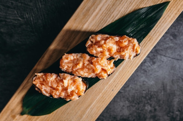 Isolierte Sushi und Brötchen auf einem dunklen, kontrastierenden Hintergrundmenüformat