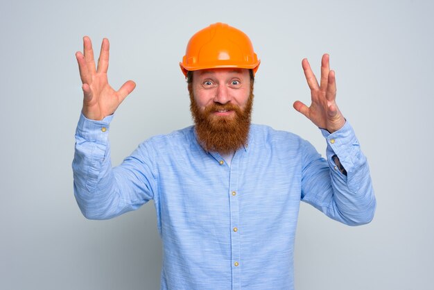 Isolierter glücklicher Architekt mit Bart und orangefarbenem Helm