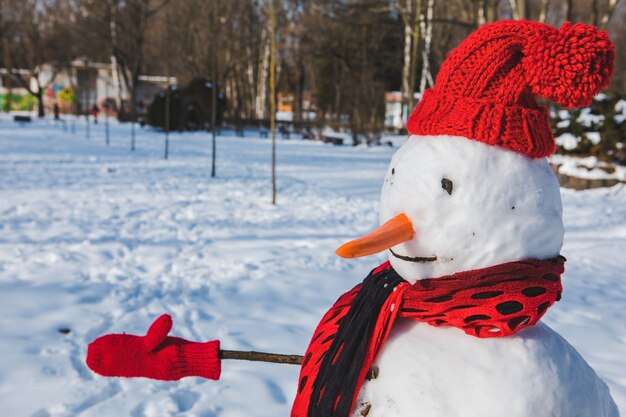 Isolierter Schneemann in der Wintersaison mit rotem Hut