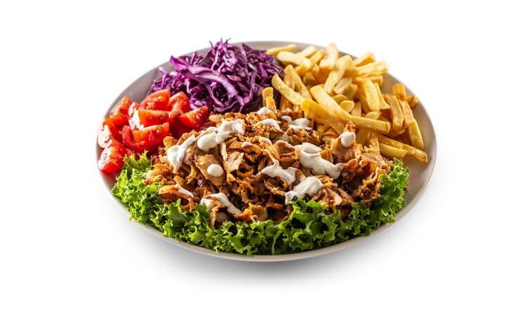 Isolierter traditioneller türkischer Hühnchen-Kebab mit leckeren Pommes, frischem Gemüse und leckerem Dressing.