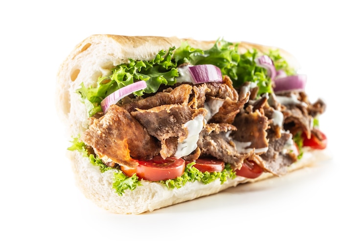 Isoliertes türkisches Kebab-Baguette mit einer großzügigen Portion Gemüse und richtig gegrilltem Kalbs- oder Hühnerfleisch.