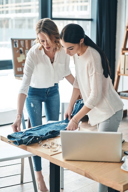 Isso pode funcionar. Mulheres bonitas olhando para jeans e tocando-o