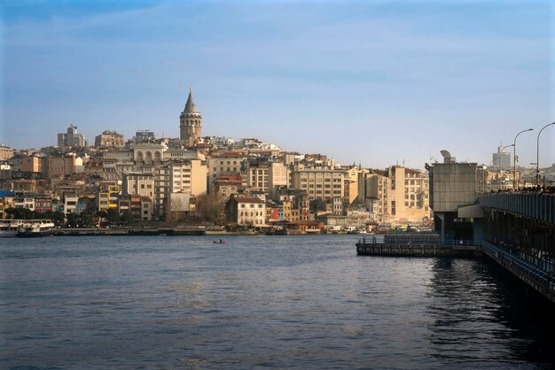 Istambul Turquia 02252023 Vista do distrito de Beyoglu com a Torre Galata e a Ponte Galata das águas da Baía do Corno de Ouro em um dia ensolarado