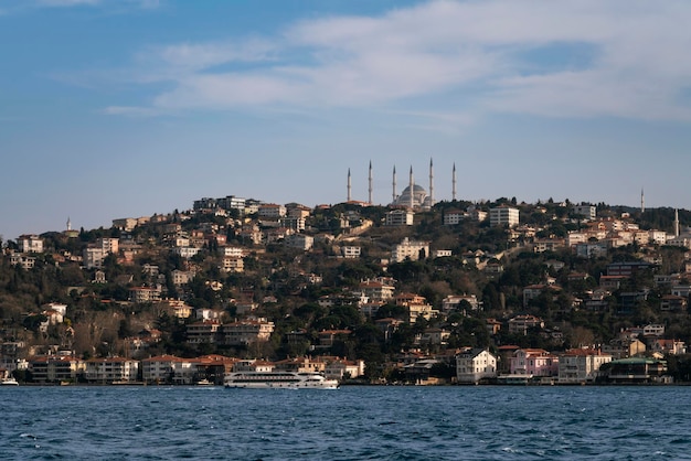 Istanbul Türkei 02252023 Blick auf den Istanbuler Stadtteil Üsküdar im asiatischen Teil der Stadt und die Große Moschee von Chamlyja vom Wasser des Bosporus aus an einem sonnigen Tag