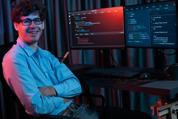IT-Entwickler schaut auf die Kamera mit Softwareentwicklungsinformationen Gusher