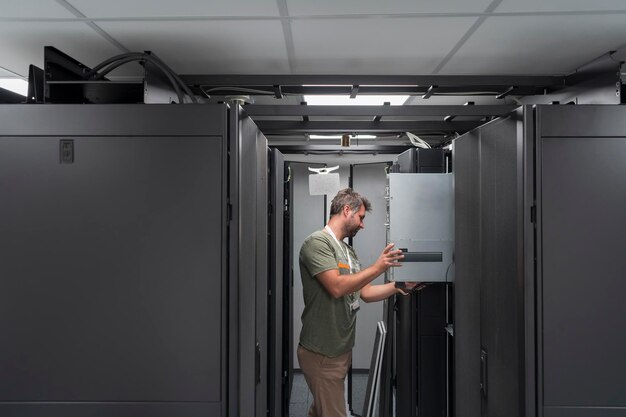 IT-Ingenieur arbeitet im Serverraum oder Rechenzentrum. Der Techniker stellt einen neuen Server eines Großrechner-Supercomputers oder einer Kryptowährungs-Mining-Farm in ein Rack.