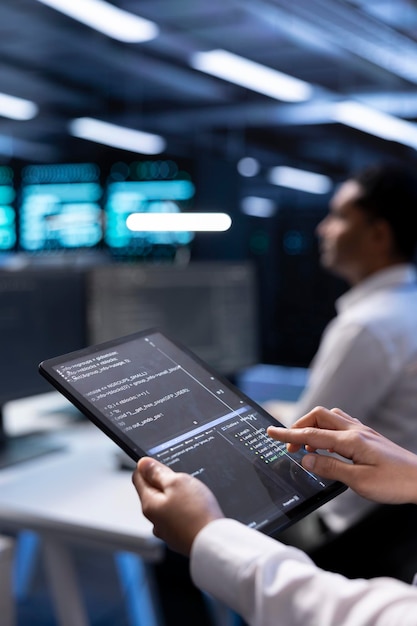 IT-Mitarbeiter, der ein Tablet im Rechenzentrum verwendet, um Systemengpässe zu überprüfen