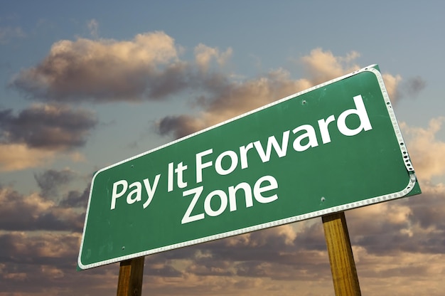 It Pay Forward Zone sinal de estrada verde e nuvens