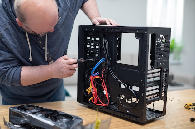 IT-Spezialist entfernt verschiedene Teile aus dem Computer mit einem Schraubendreher