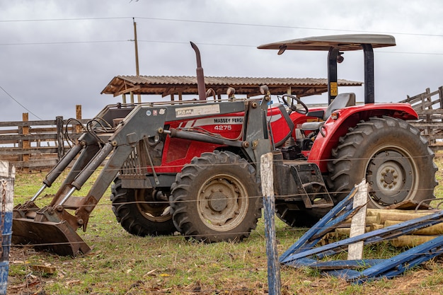 Itaja, Goias, Brasil - 10 14 2021: Tractor rojo Massey Ferguson modelo MF 4275 con cargador adjunto