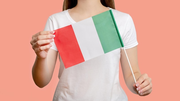 Itália bandeira turnê européia Mulher segurando o símbolo nacional oficial tricolor com três listras verticais verdes brancas vermelhas isoladas em borrão fundo rosa coral Cultura nacional