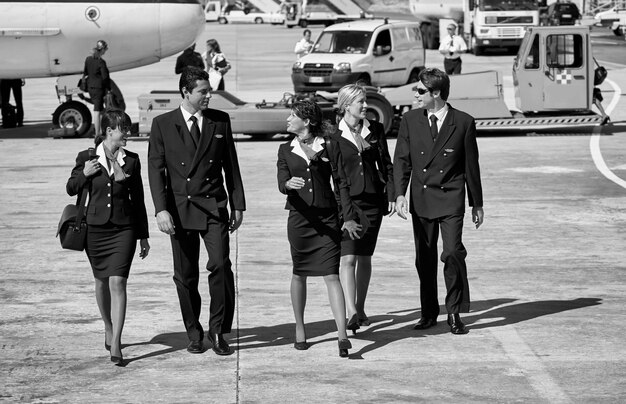 Foto italia, cerdeña, aeropuerto internacional de olbia, asistentes de vuelo cerca de un avión