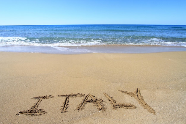 Foto italia escrito en la playa de arena