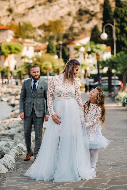 Italia, Lago de Garda. Hermosa familia a orillas del lago de Garda en Italia, al pie de los Alpes. Padre, madre e hija en Italia.