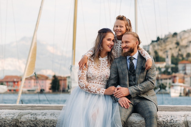 Italia, Lago de Garda. Hermosa familia a orillas del lago de Garda en Italia, al pie de los Alpes. Padre, madre e hija en Italia.