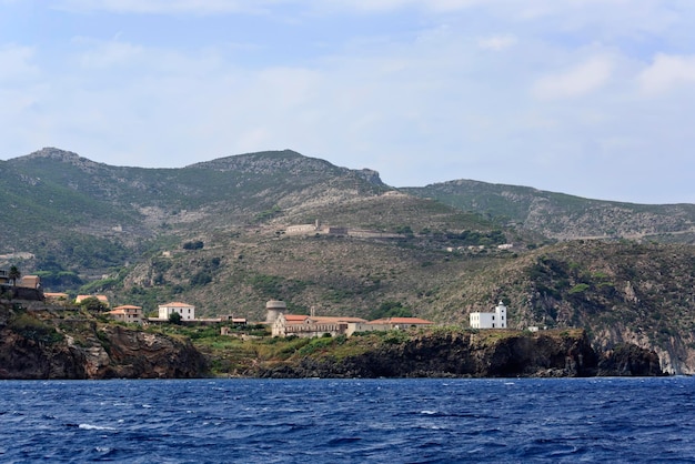 Italia mar Tirreno isla de Capraia vista de la rocosa costa occidental de la isla y un faro