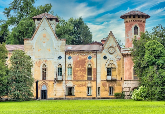 ITALIA, MIRADOLO - CIRCA AGOSTO 2020: castillo de diseño gótico ubicado en un jardín italiano, lleno de misterio, con luz del atardecer.