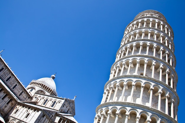 Foto italia - pisa. la famosa torre inclinada sobre un fondo azul perfecto