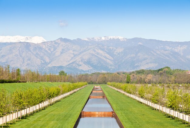 Itália - piscina de água em campo verde com montanhas dos Alpes no fundo