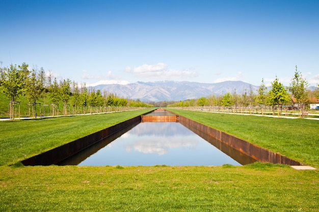 Itália - piscina de água em campo verde com montanhas dos Alpes no fundo