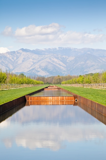 Itália - piscina de água em campo verde com montanhas dos Alpes no fundo