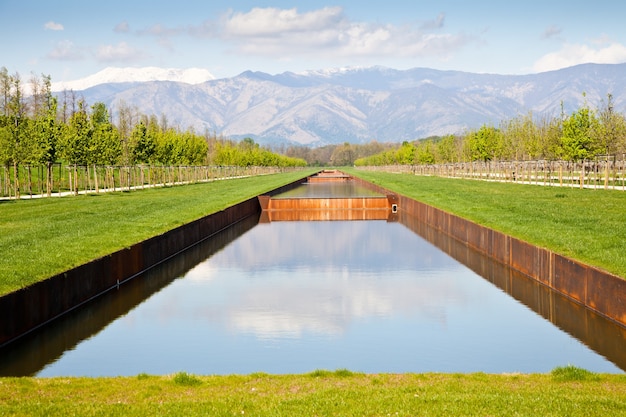 Itália - piscina de água em campo verde com montanhas dos Alpes no fundo