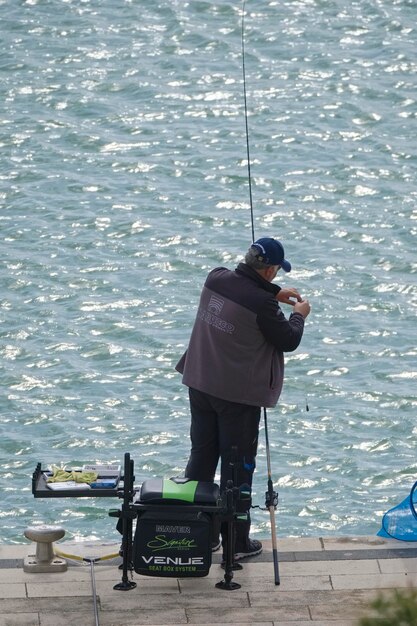 Itália, Sicília, Marina di Ragusa (Província de Ragusa); 3 de novembro de 2019, pescador pescando no porto - EDITORIAL