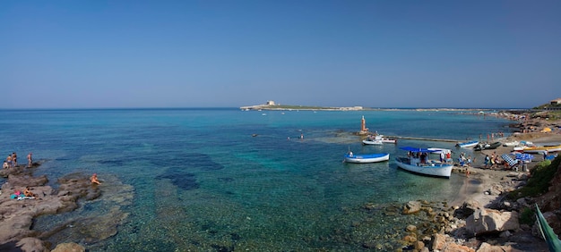 Foto italia, sicilia, portopalo (provincia de siracusa): 22 de agosto de 2006 - gente en la playa (la isla de capo passero en el fondo) - editorial