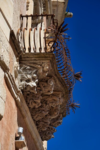 Italia, Sicilia, Ragusa Ibla, la fachada barroca del Palacio Cosentini (monumento de la UNESCO), estatuas ornamentales bajo un balcón