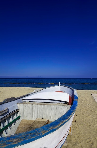 Itália, Sicília, Tindari, barco de pesca na praia e as Ilhas Eólias ao fundo