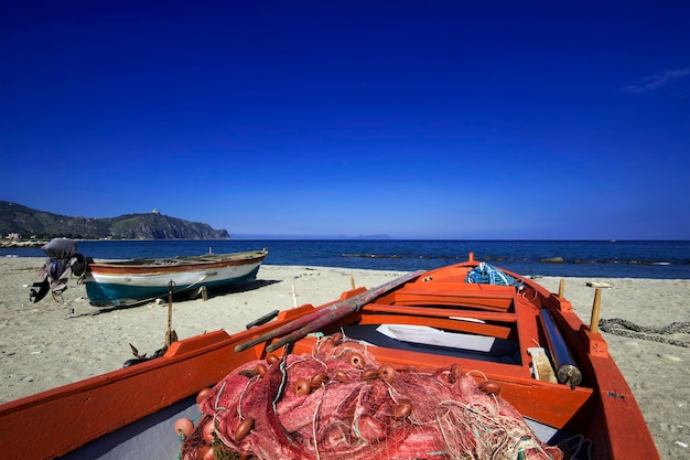 Itália, Sicília, Tindari, barcos de pesca na praia e as Ilhas Eólias ao fundo