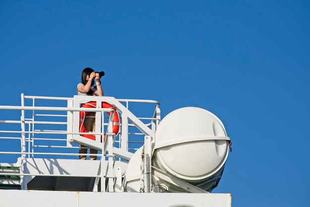 Italien, Kanal von Sizilien, Frau beim Fotografieren auf einer der Fähren, die Sizilien mit Kalabrien verbinden