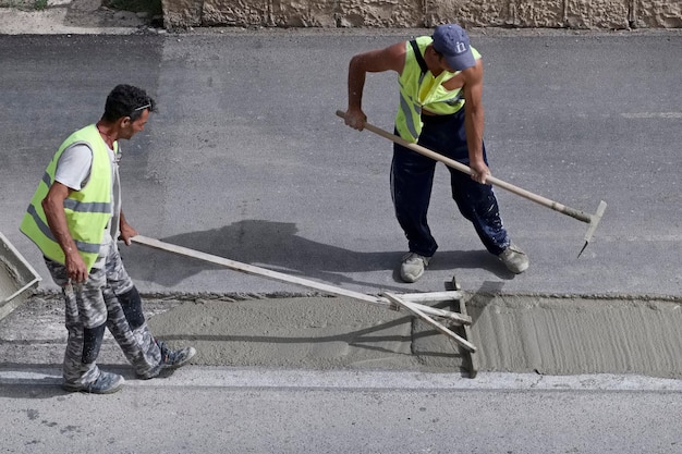 Italien, Sizilien; 12. Mai 2016, Männer bei der Reparatur einer Straße – EDITORIAL